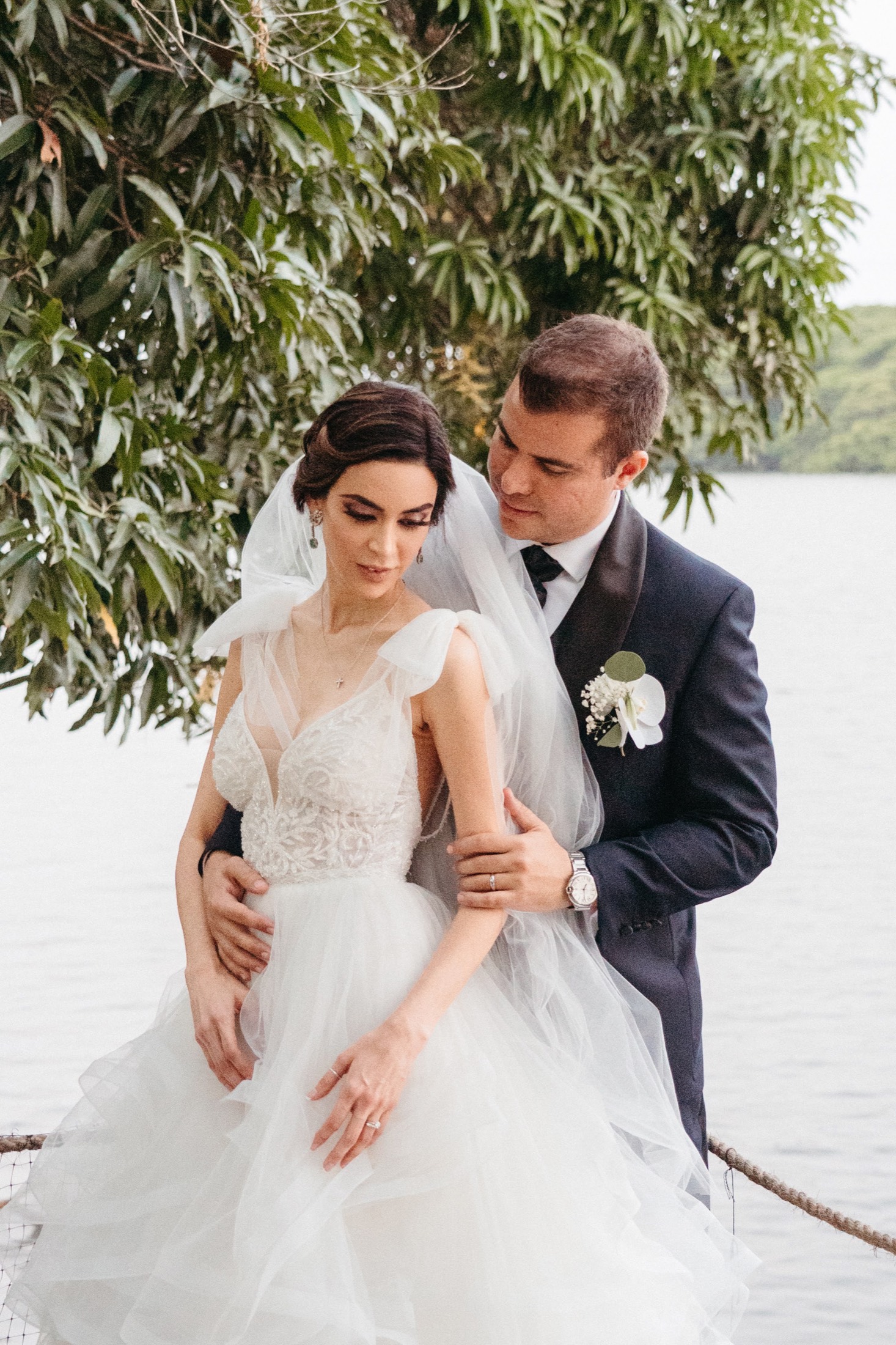 Novios abrazados junto al lago en una boda de destino en México, fotografía de Miguel Beltrán.