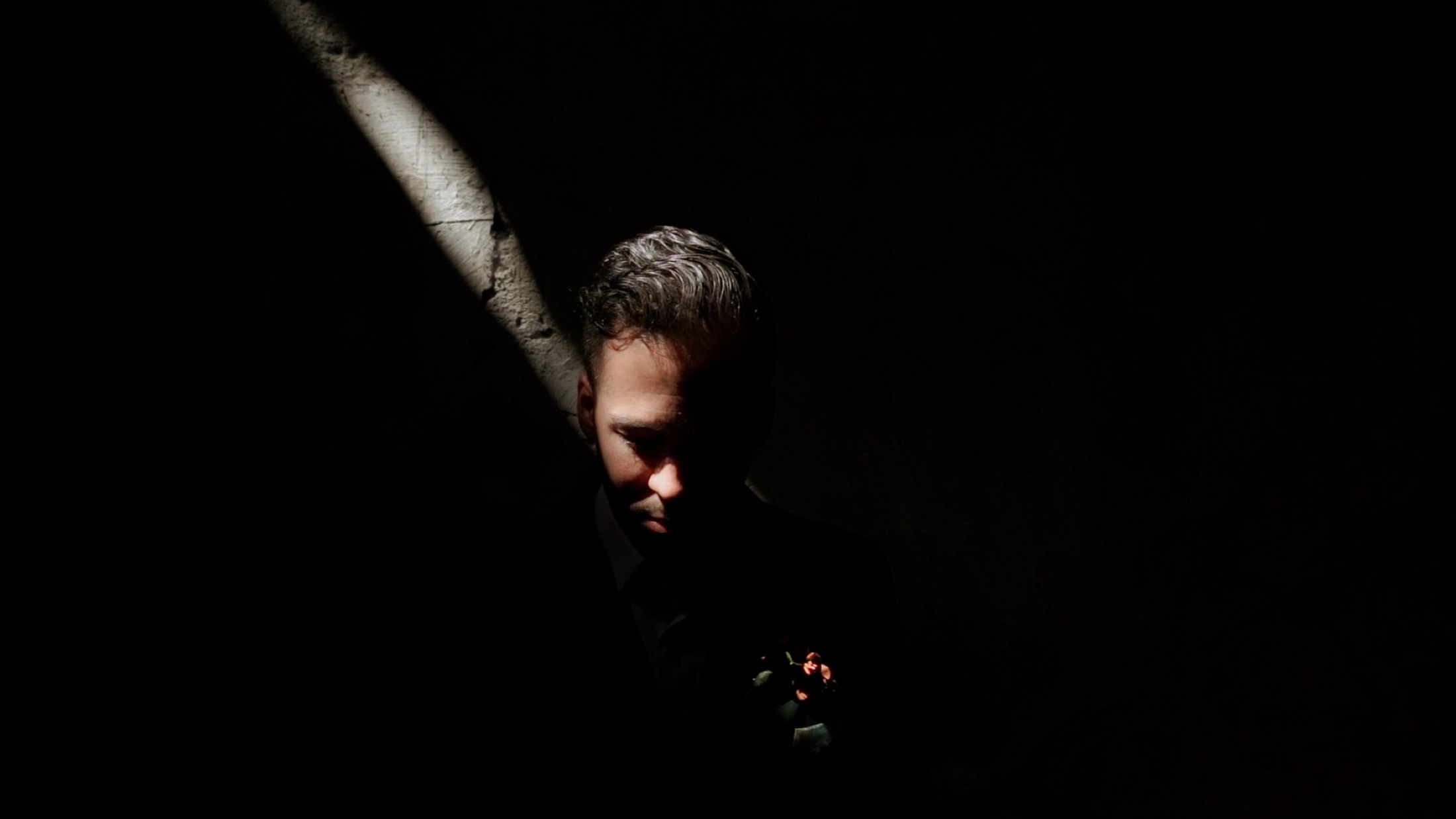 Retrato del novio bajo un haz de luz tenue, fotografía de bodas en México.